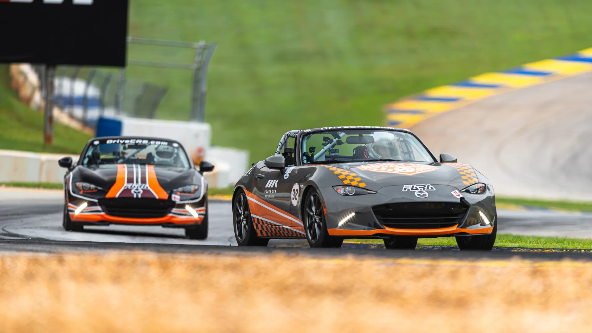 Virginia Tech’s black and orange No. 55 Mazda MX-5 follows the University of Tennessee’s gray No. 98 through a turn at Michelin Raceway Road Atlanta.